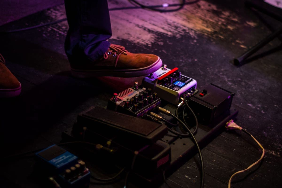 A fuzz pedal and a reverb pedal lit in low light