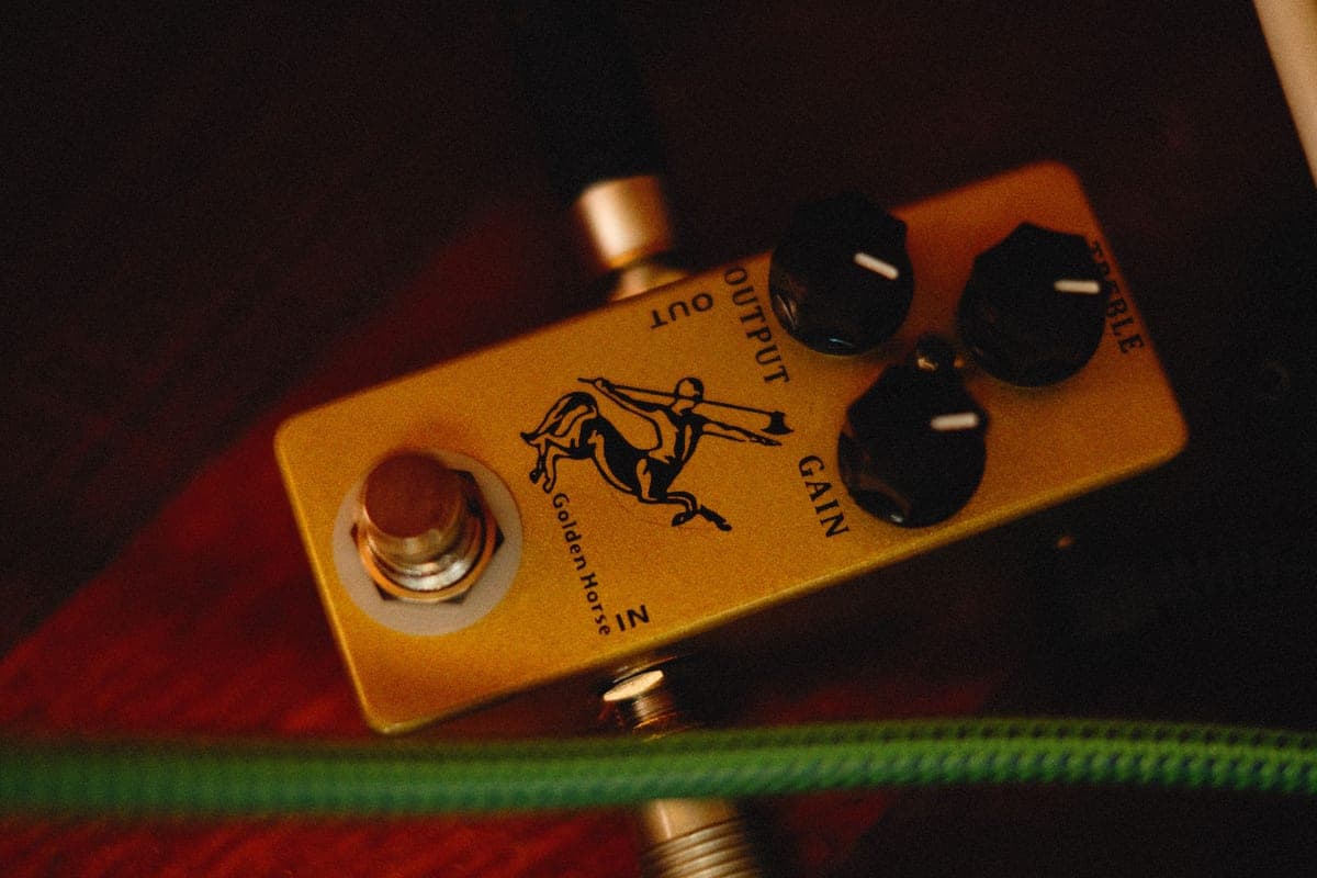 A gold-finished overdrive pedal photographed close