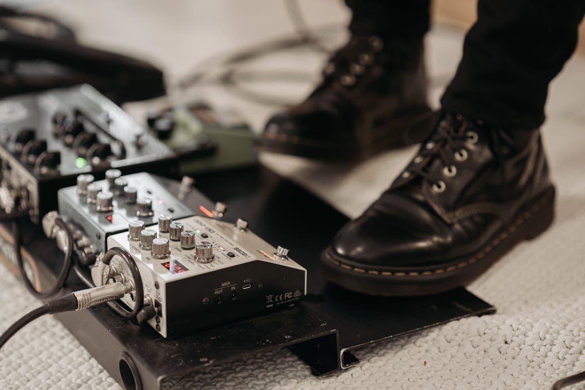 Short right-angle patch cables coiled on a pedalboard