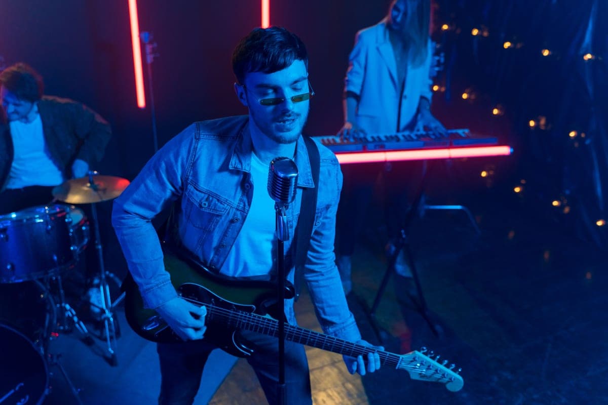A guitarist playing a lead line under stage lighting